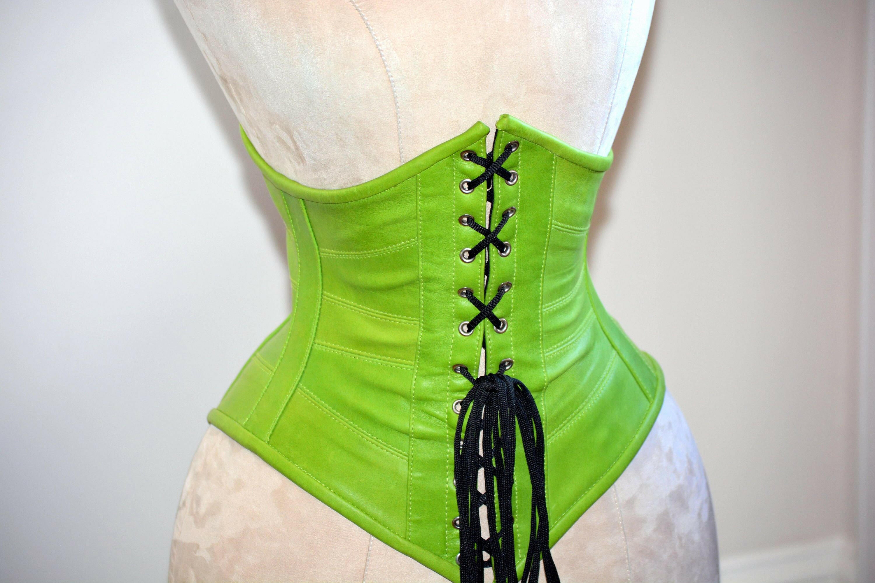 Espartilho de couro sob o busto com desossado de aço verde autêntico e  moderno. Cinto verde da moda em couro