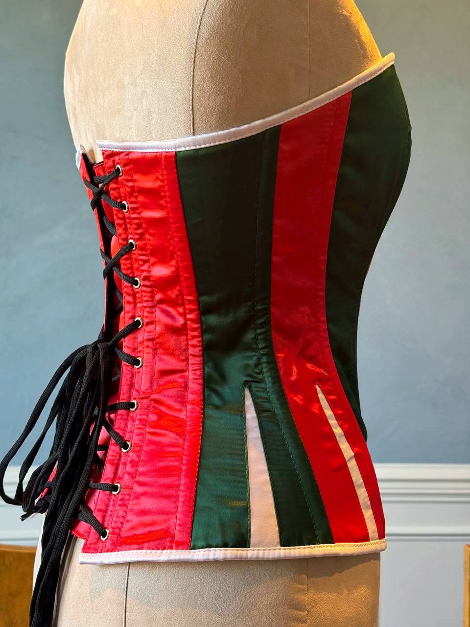 
                  
                    Corset rosso e verde in raso con Babbo Natale bianco. Il corsetto è realizzato personalmente secondo le tue misure.
                  
                