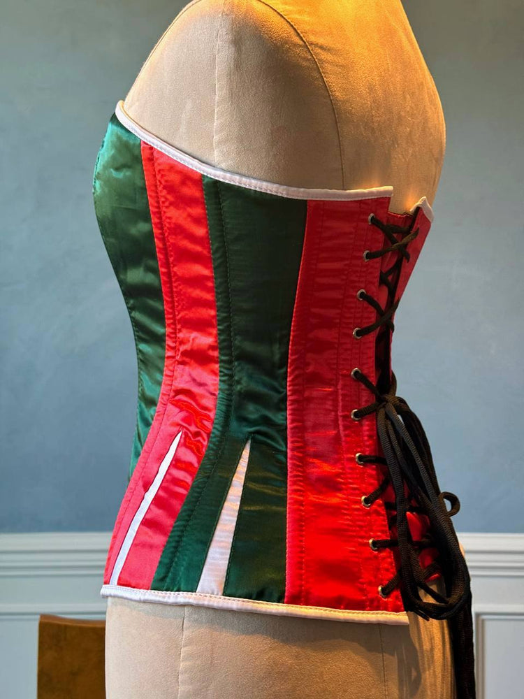 
                  
                    Corset rosso e verde in raso con Babbo Natale bianco. Il corsetto è realizzato personalmente secondo le tue misure.
                  
                