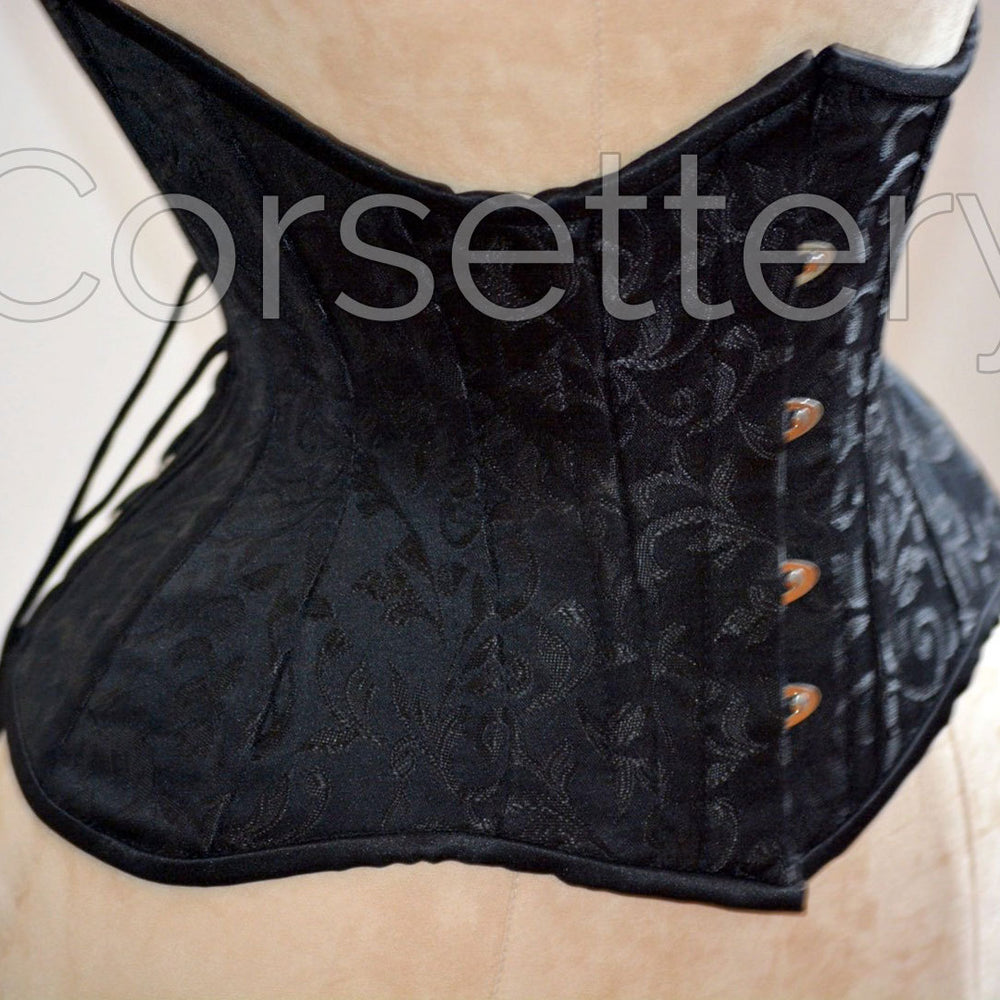 
                  
                    Double row steel boned underbust corset of short design with long hips made of brocade. Corsettery
                  
                