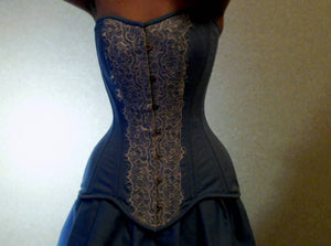 Light blue steel-boned overbust hourglasses corset for tight lacing covered by chantilly laces. Lace Addicted Corsettery collection. Corsettery