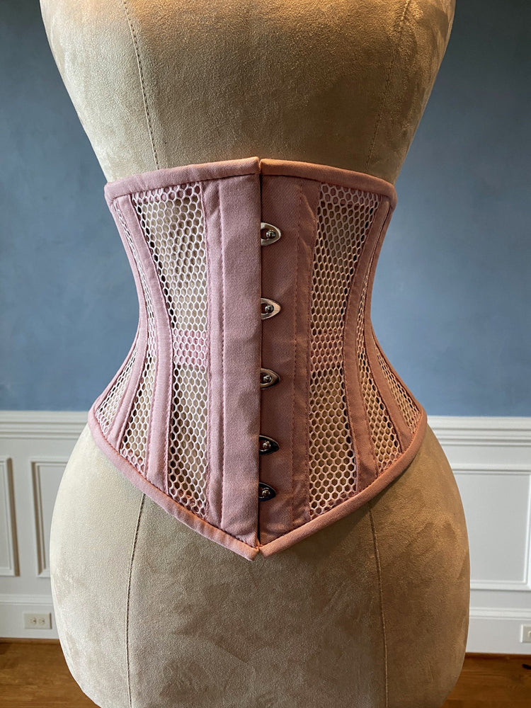 Corset rose de sous-vêtements en acier véritable désossé en maille transparente et coton. Véritable corset d'entraînement à la taille pour un laçage serré.