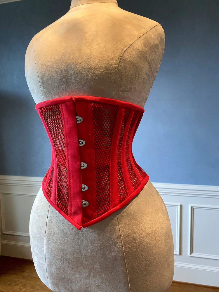 Corset rouge de sous-vêtements en acier véritable désossé en maille transparente et coton. Véritable corset d'entraînement à la taille pour un laçage serré.