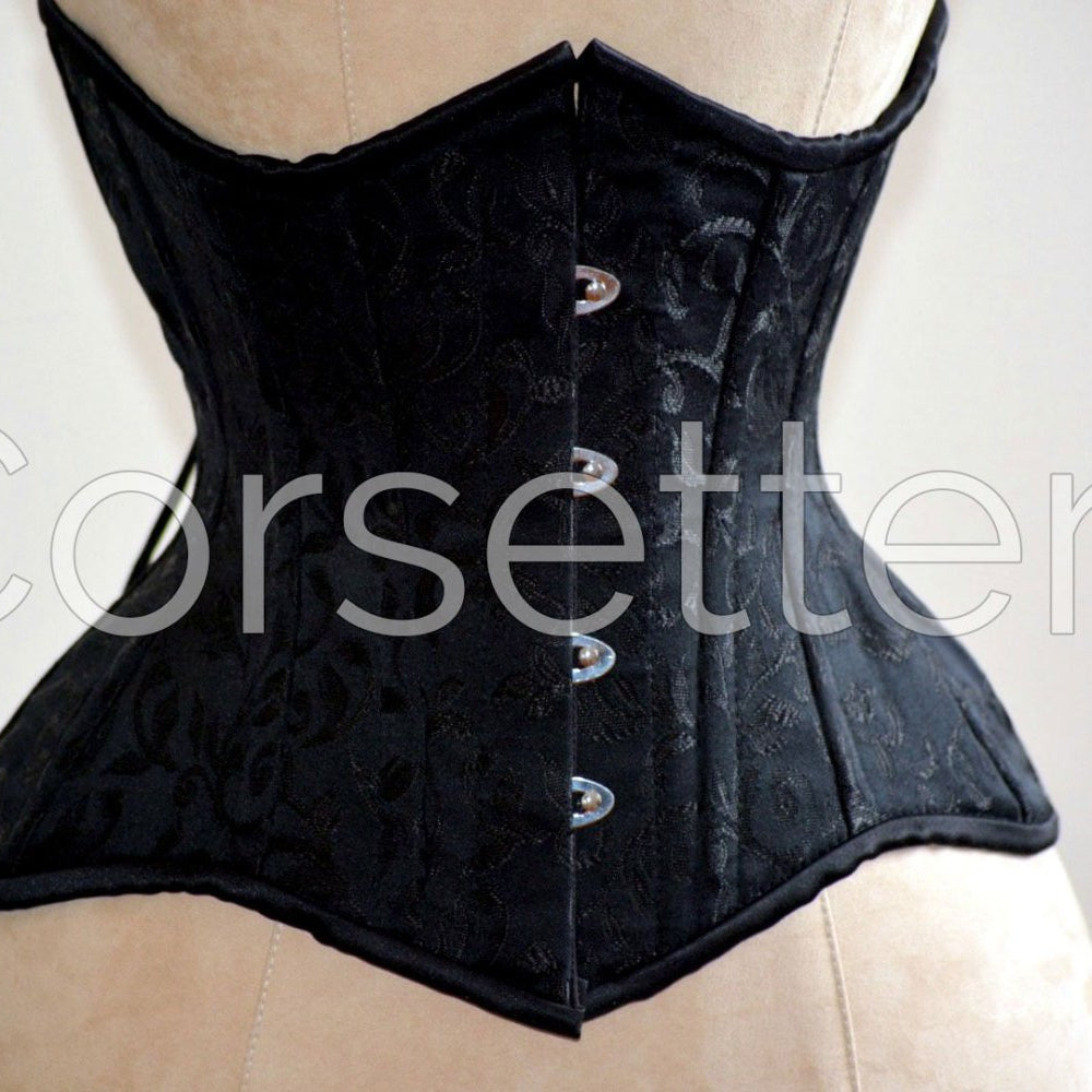 
                  
                    Double row steel boned underbust corset of short design with long hips made of brocade. Corsettery
                  
                